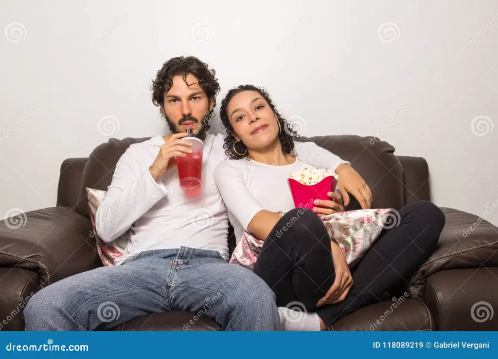 Waktu Menonton yang Nyaman Pasangan menonton film di rumah dengan nyaman.